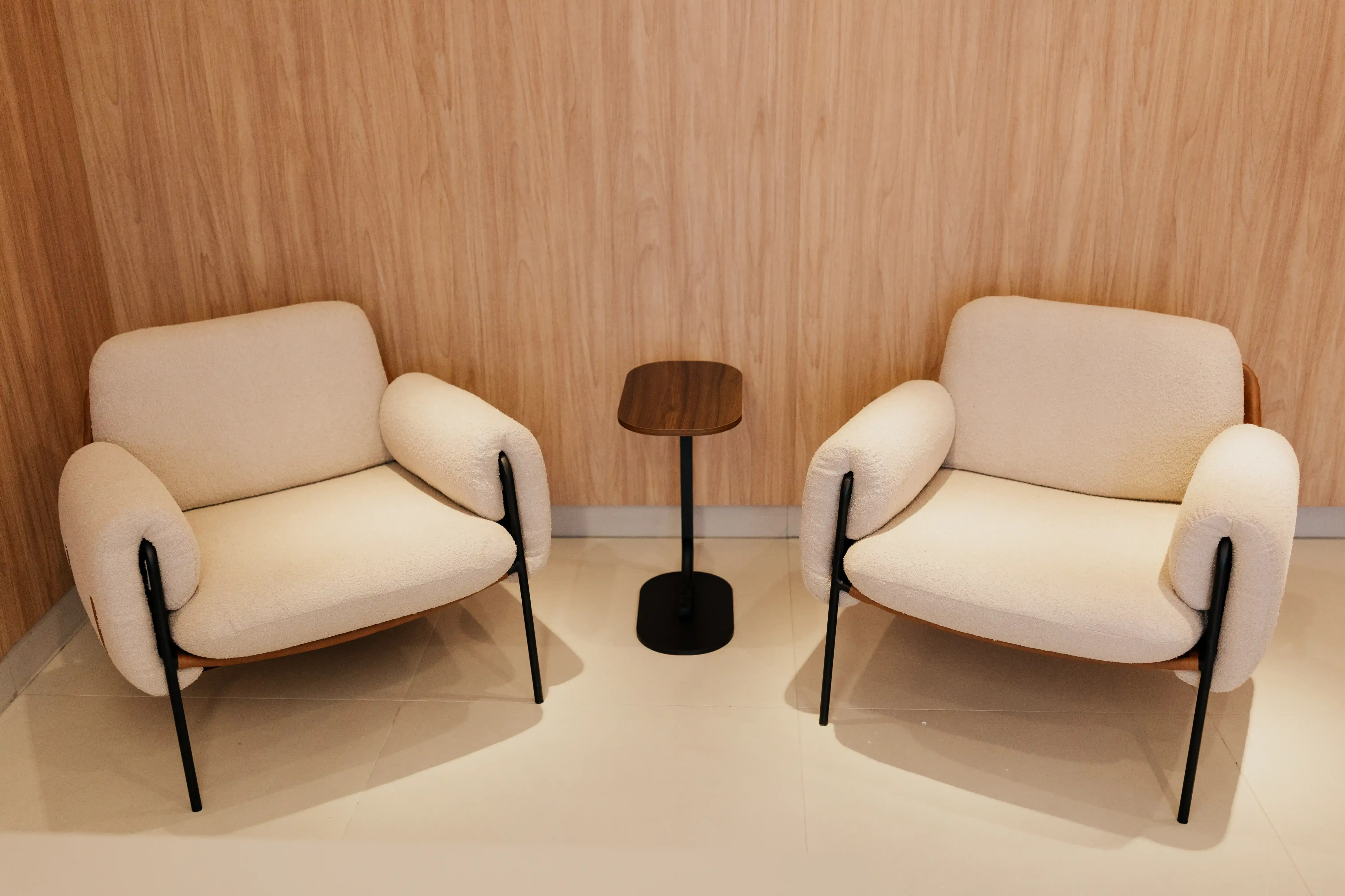 Poltronas e mesa de apoio na recepção do escritório